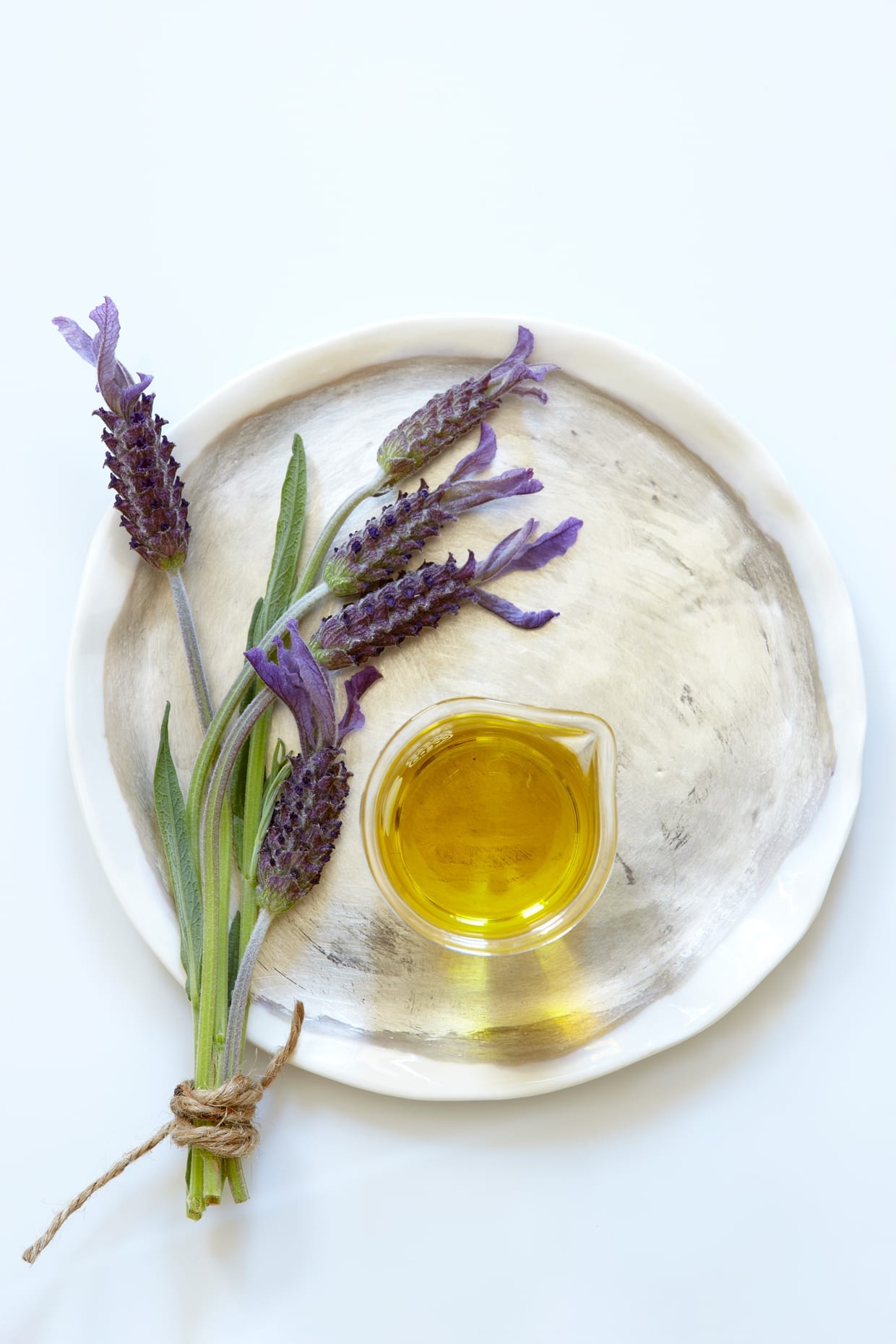 Lavender and lavender oil on a plate.