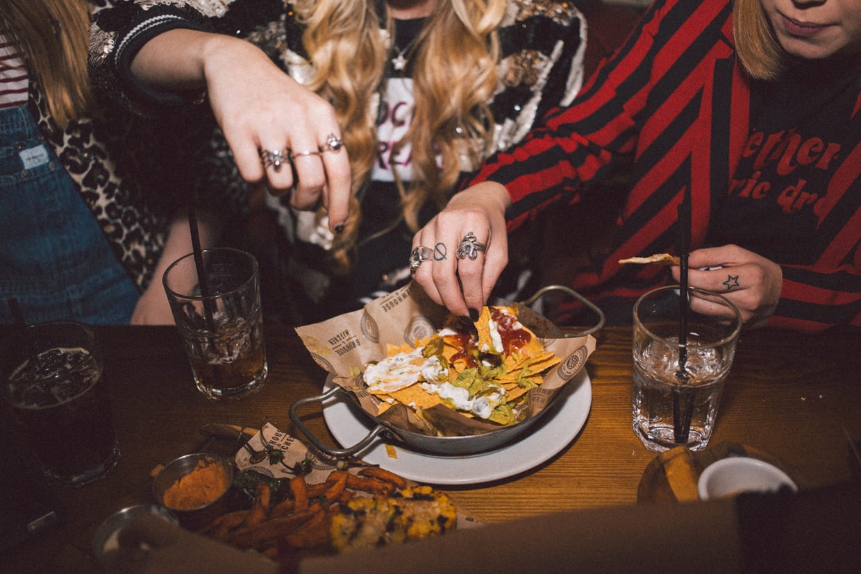 A group of women eating nachos.
