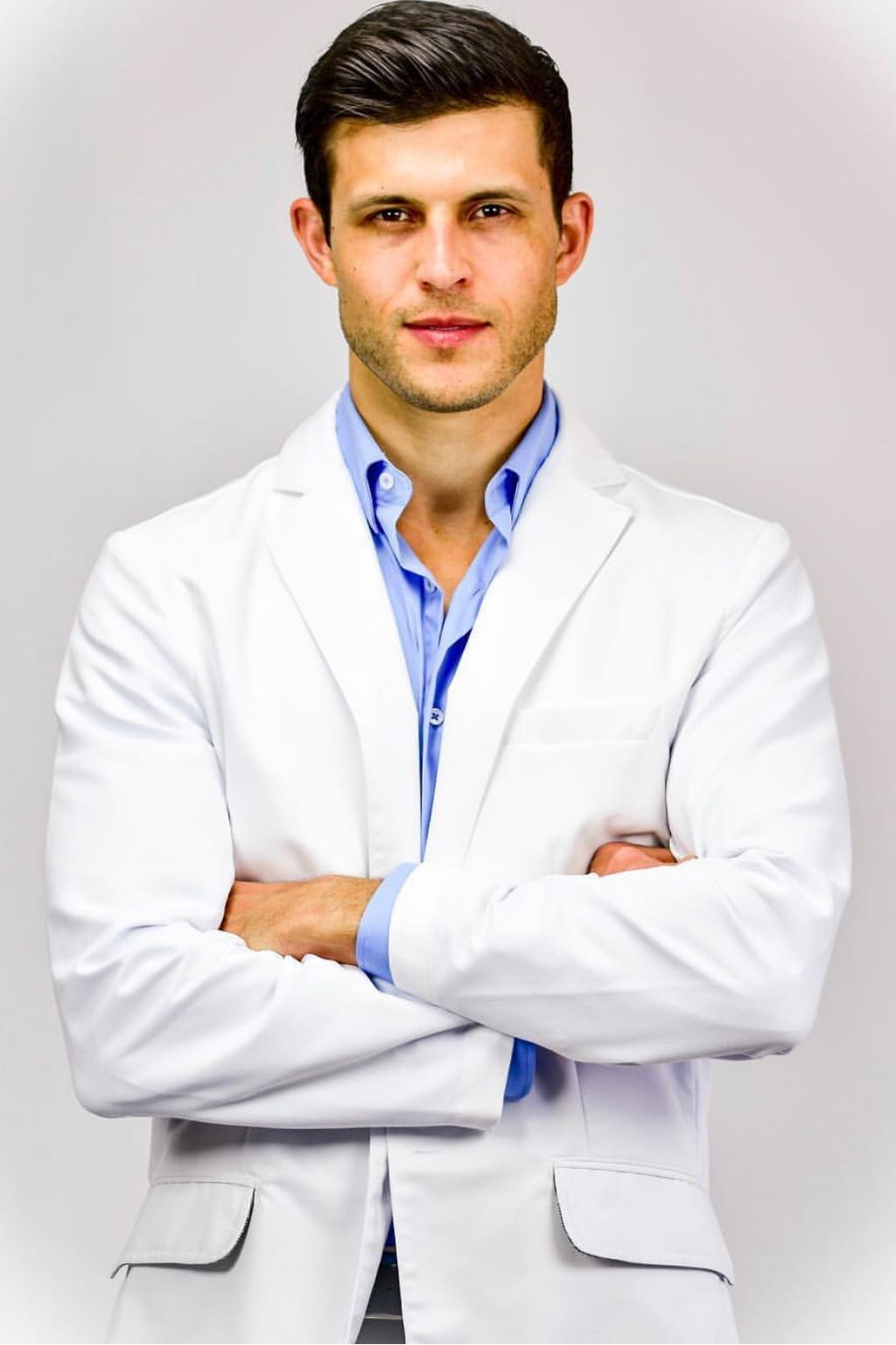 A photo of a man in a white medical coat.