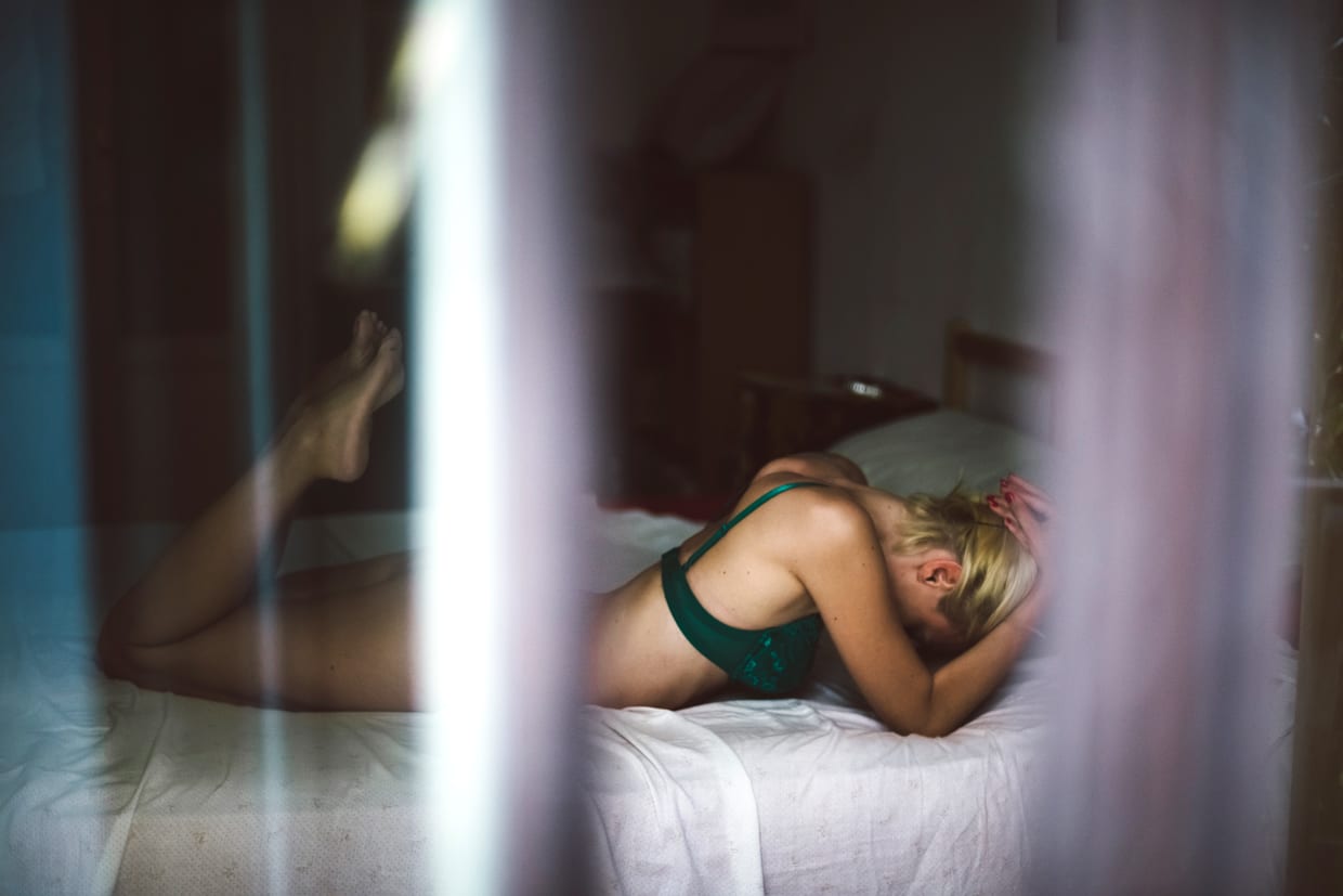 A blonde woman lying on a bed.